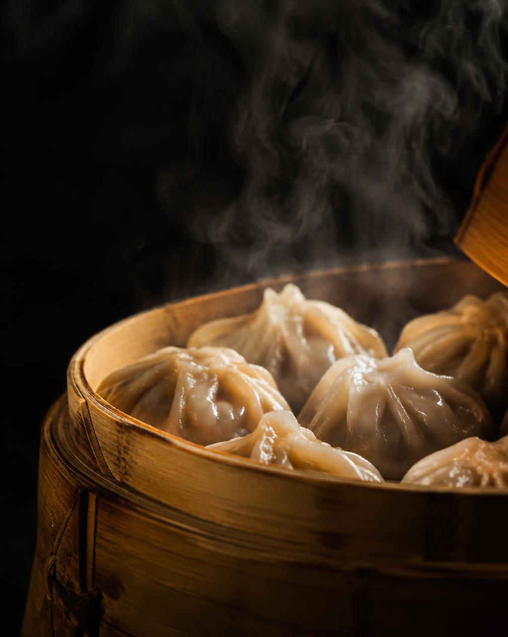 Steaming soup dumplings in a bamboo basket
